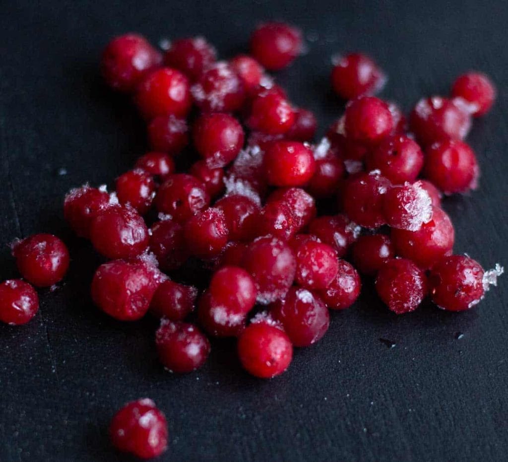 frozen lingonberries on a dark surface