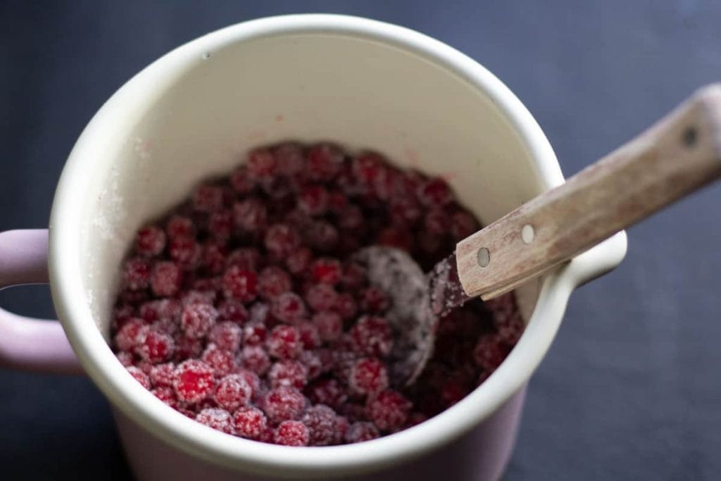 Lingonberries mixed with sugar in a pot