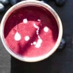 a birdseyeview of a cup of swedish blueberry soup with blueberries in the background