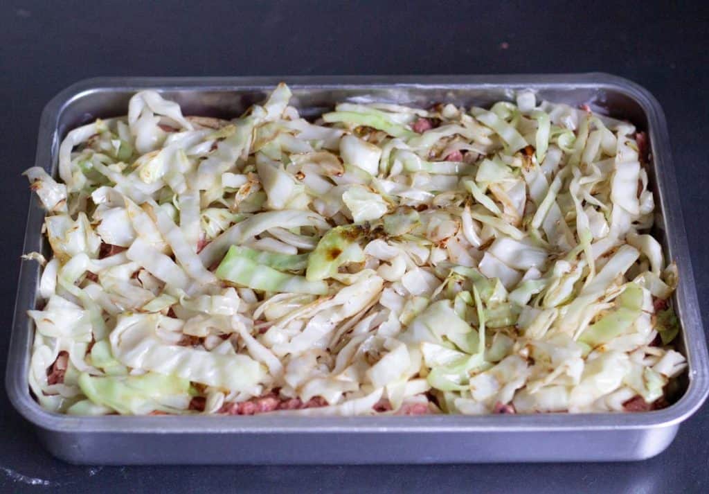 an oven form with layered cabbage and meatloaf ingredients