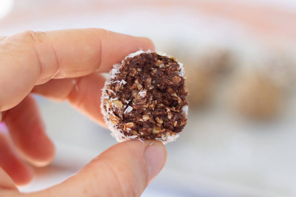 a hand holding half a Swedish chocolate ball
