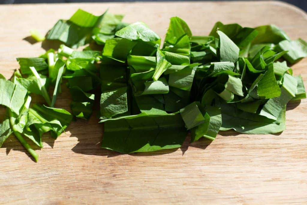 chopped ramps or wild garlic on a wooden chopping board
