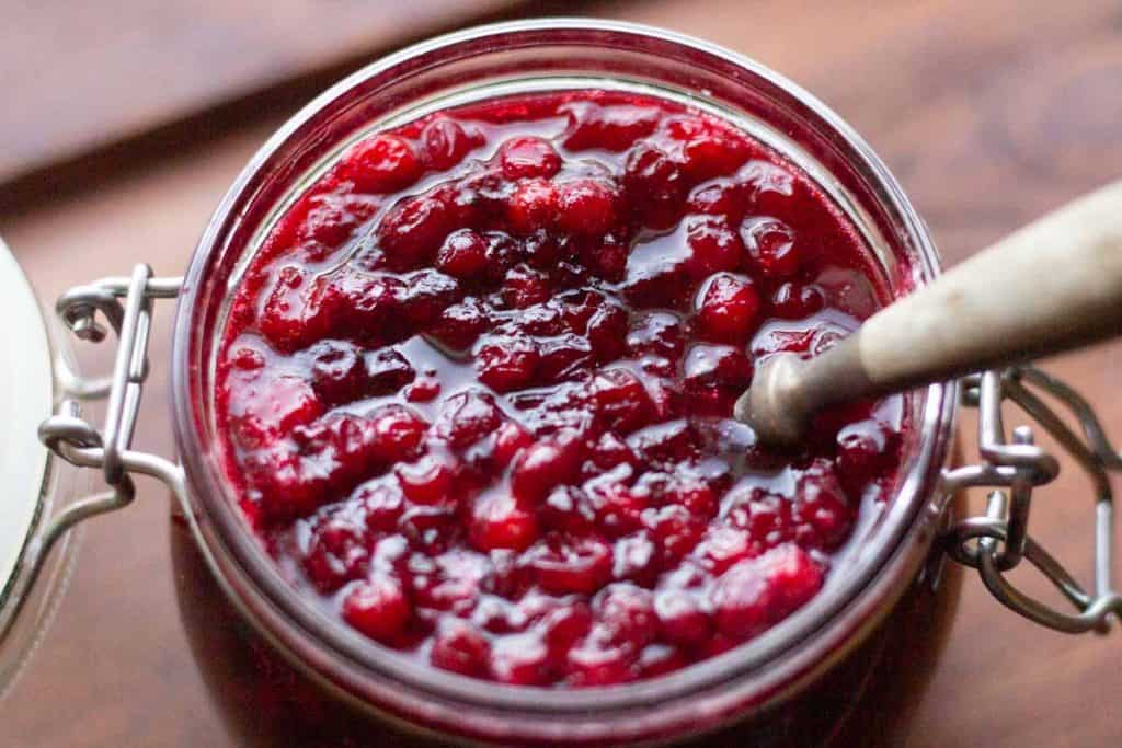 overhead shot of lingonberry jam in a glass jar