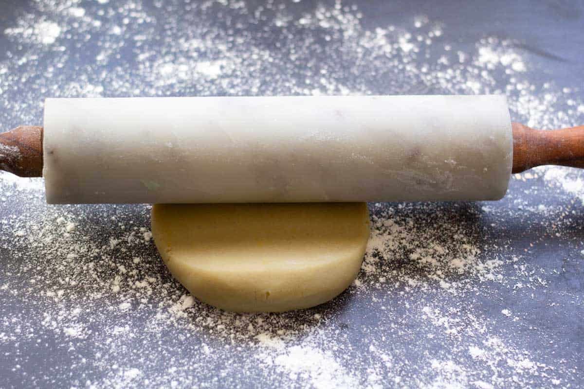 a rolling pin rolling out shorbread cookie dough