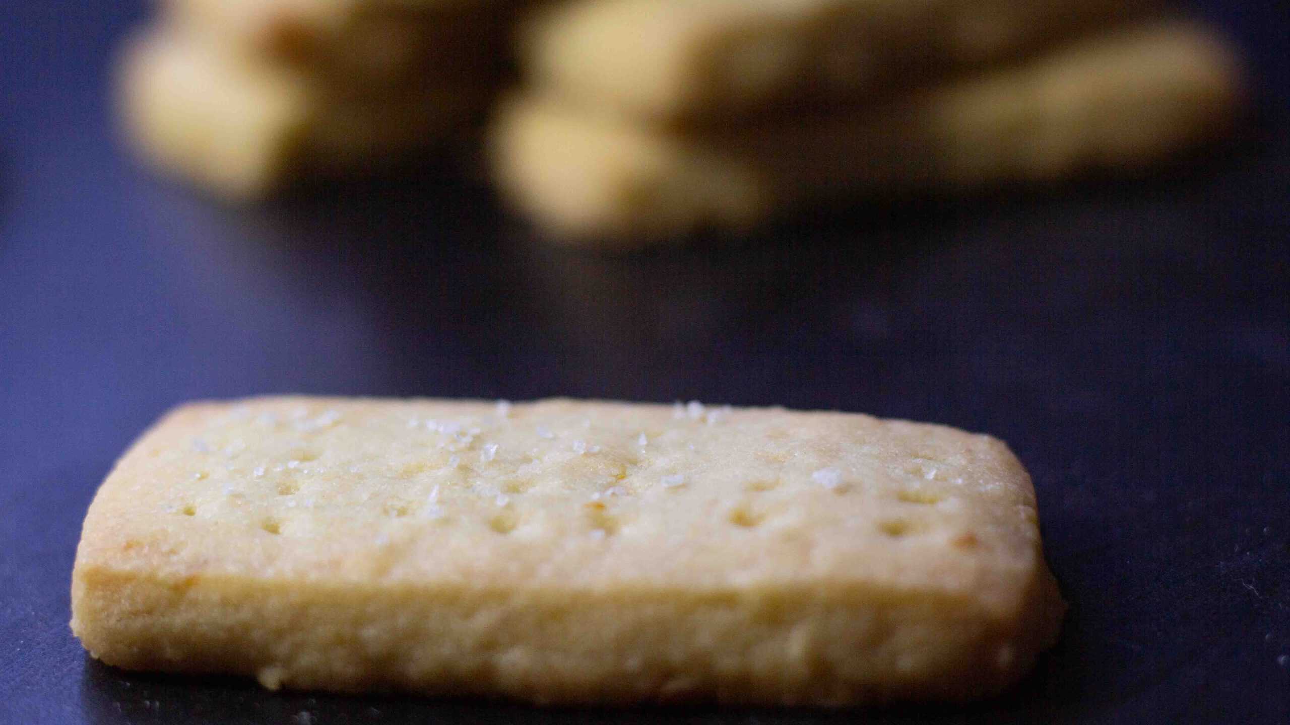 a close up of a salted lemon shortbread cookie. There are more cookies in the background