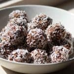 Swedish chocolate balls rolled in shredded coconut and served in a white ceramic bowl