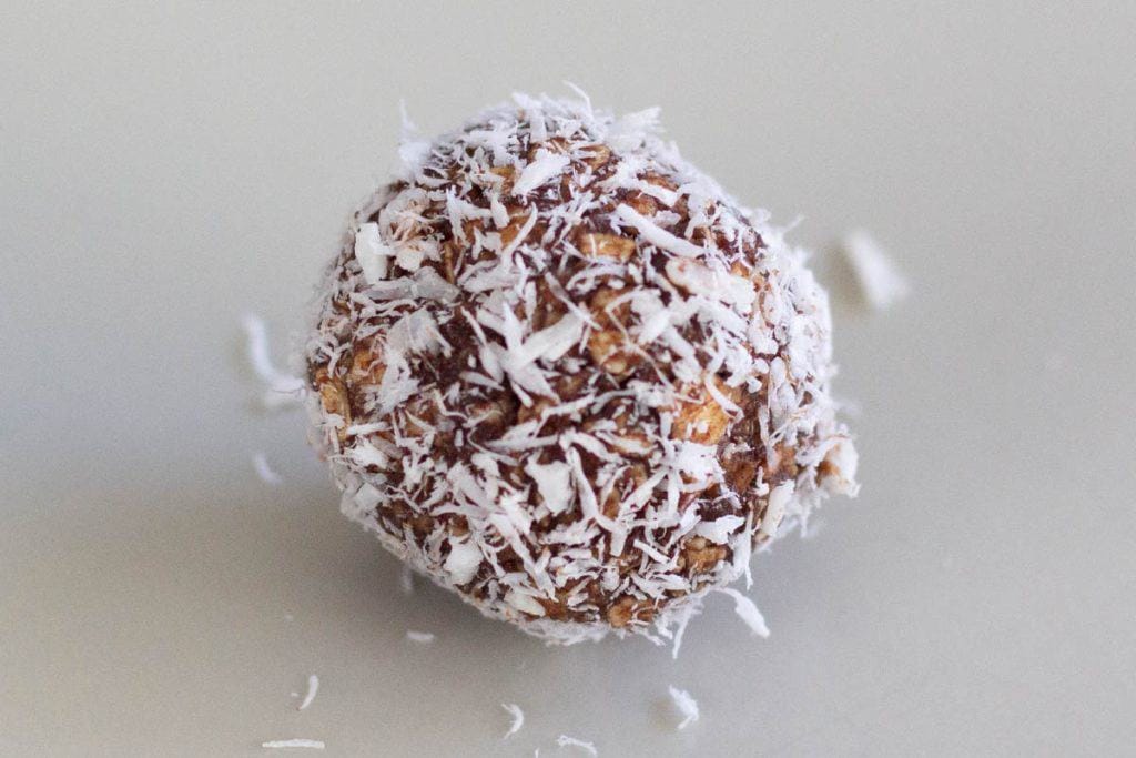 A close-up image of a Swedish chocolate ball rolled in shredded coconut