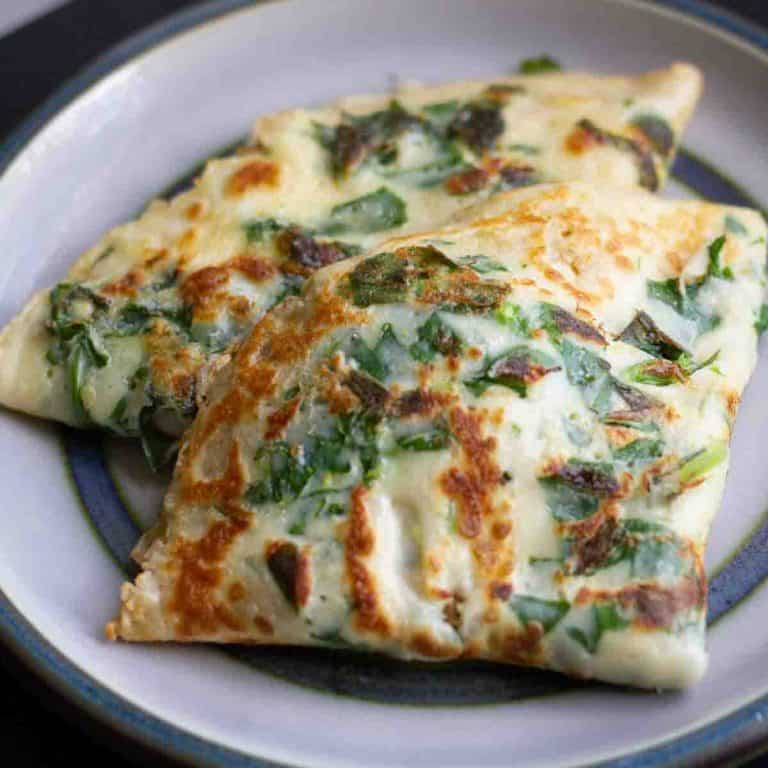 wild garlic pancakes on a blue and white ceramic plate