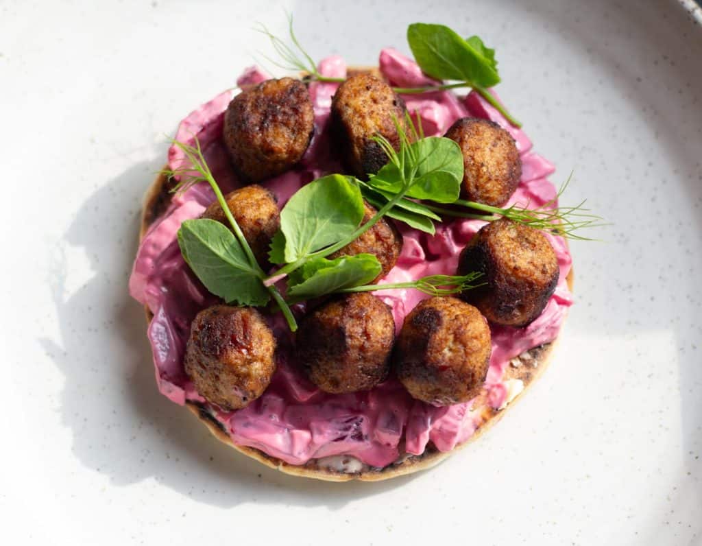 A Swedish meatball Sandwich served on a white ceramic plate