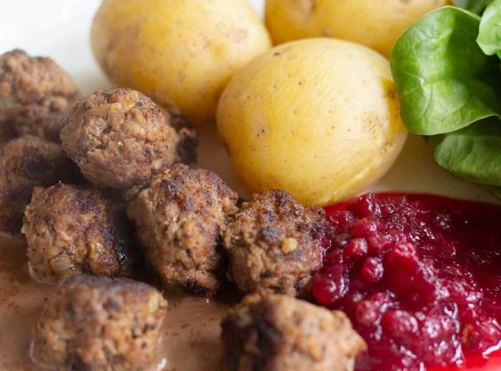 Swedish meatballs served with lingonberry jam, boiled potatoes and cream sauce