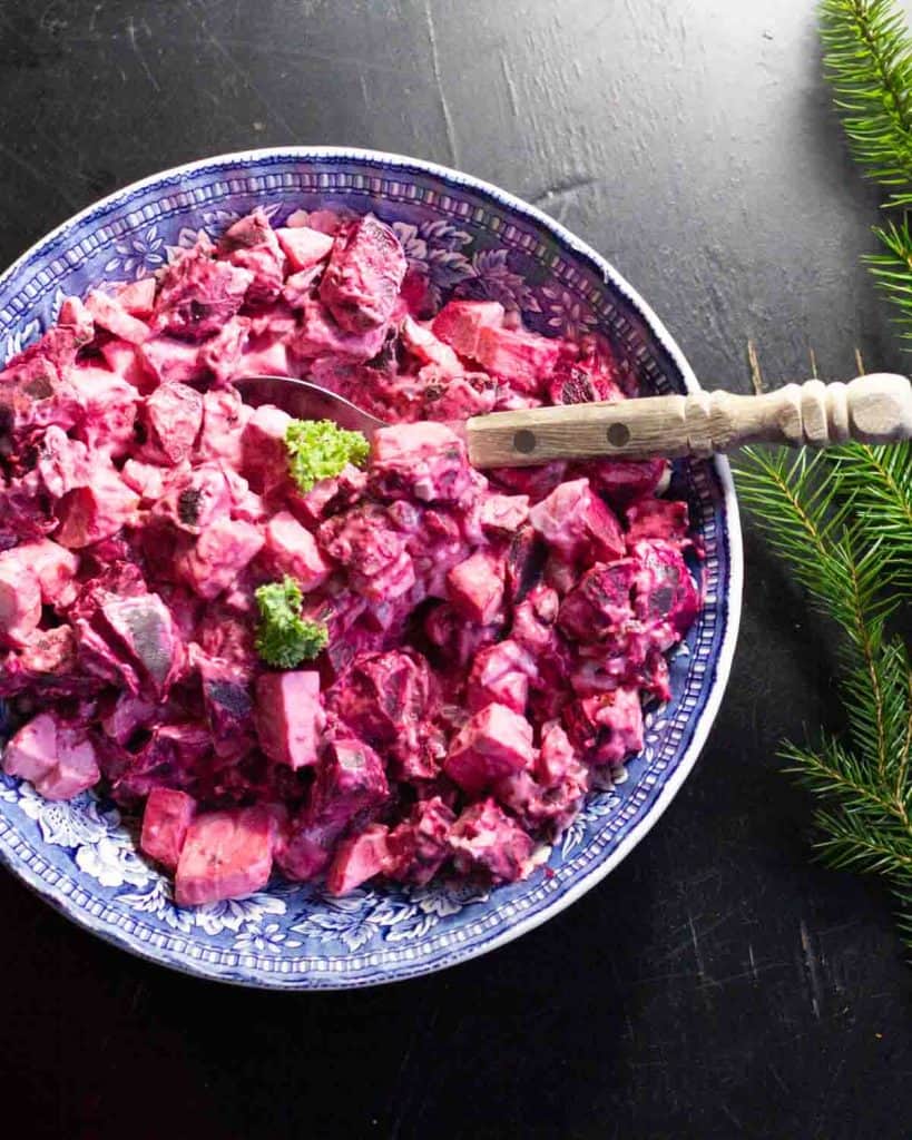 Swedish Beetroot and Apple Salad in a vintage bowl with an wooden serving spoon on a dark table