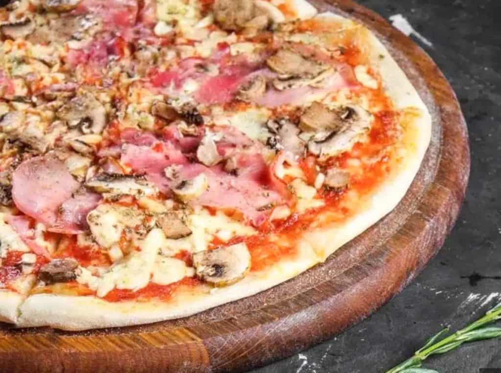 A thing-crusted Swedish Pizza with mushrooms, hand and mozzerella
