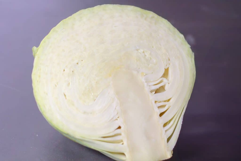 Half a head of white cabbage on a dark table
