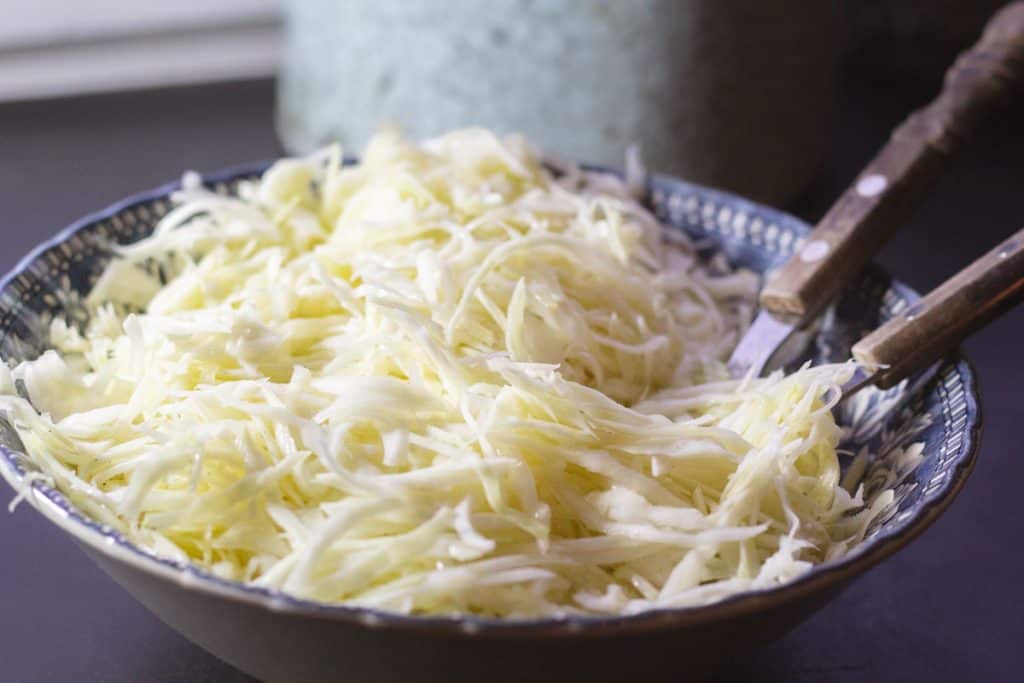 Side view of a blue bowl filled with Swedish Pizza sallad.