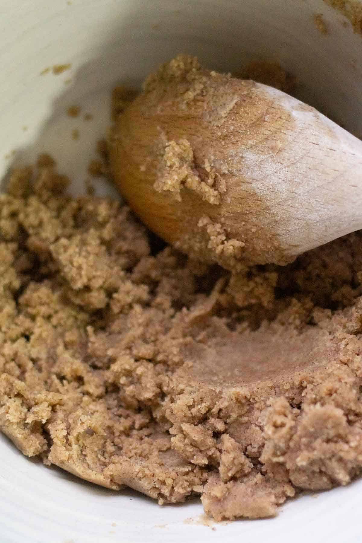 A wooden spoon mixing gingerbread shortbread dough