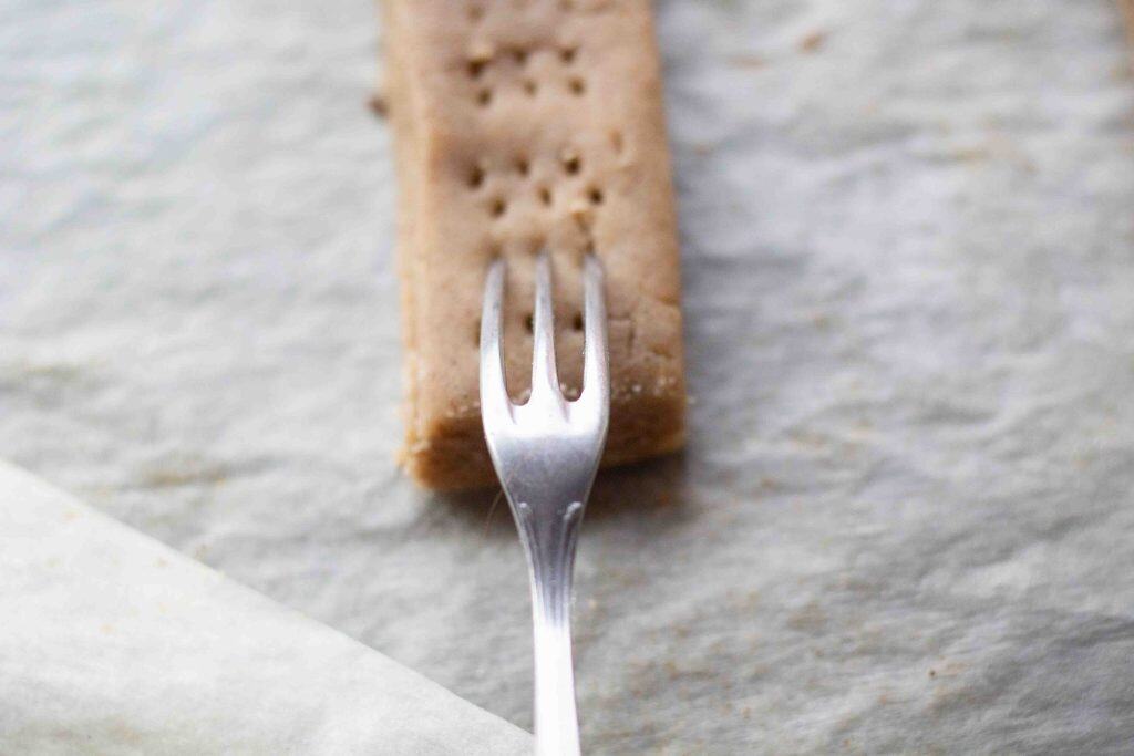 A fork making small pricks ina shortbread finger