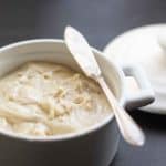 Horseradish butter in a white ceramic ramekin with a silver serving knife
