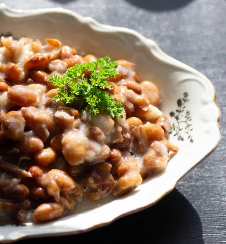 Swedish brown beans served in a ceramic dish and garnished with a sprig of parsley