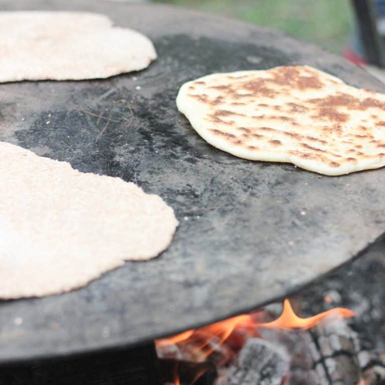 Viking bread cooking on a cast-iron skillet over an open fire