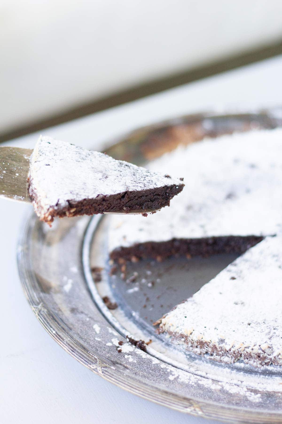 Chocolate cake with powdered sugar dusting, being served