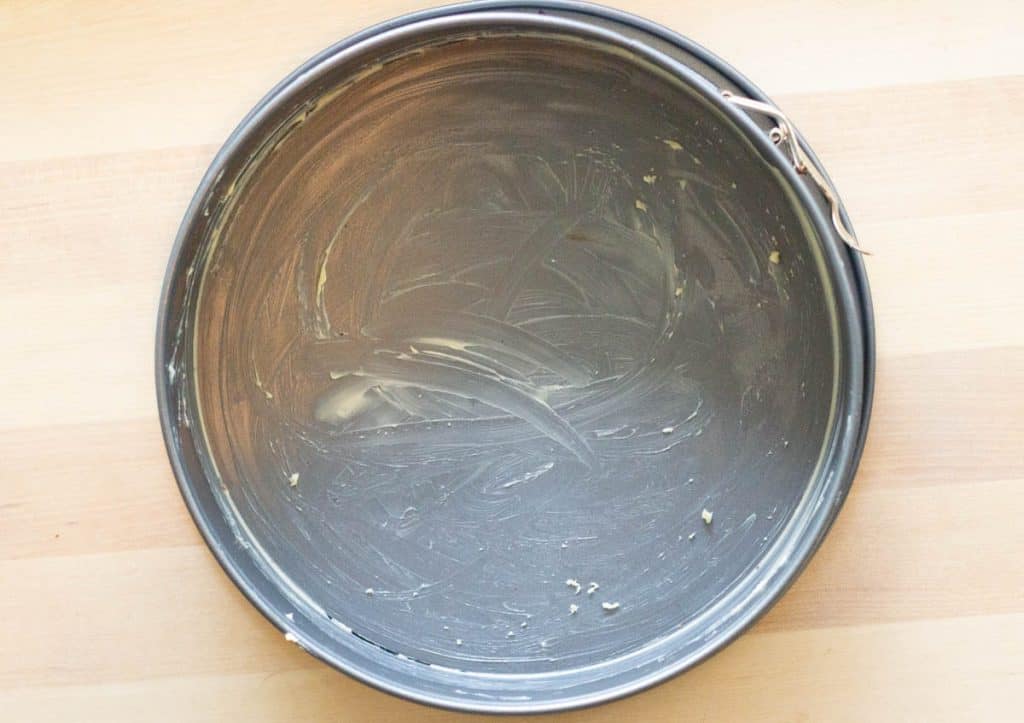 an overhead image of a springform coated in butter